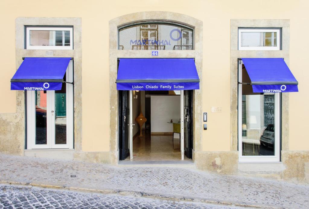 a building with blue awnings on the front of it at Martinhal Lisbon Chiado in Lisbon