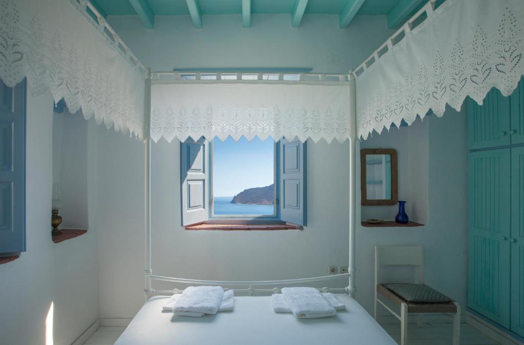 a bedroom with a window and a bed with towels at Theologos Houses in Grikos
