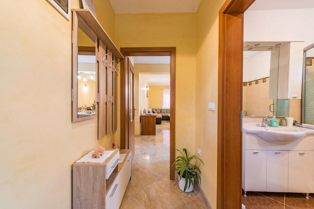 łazienka z umywalką i lustrem w obiekcie Apartment Sandi w mieście Tinjan