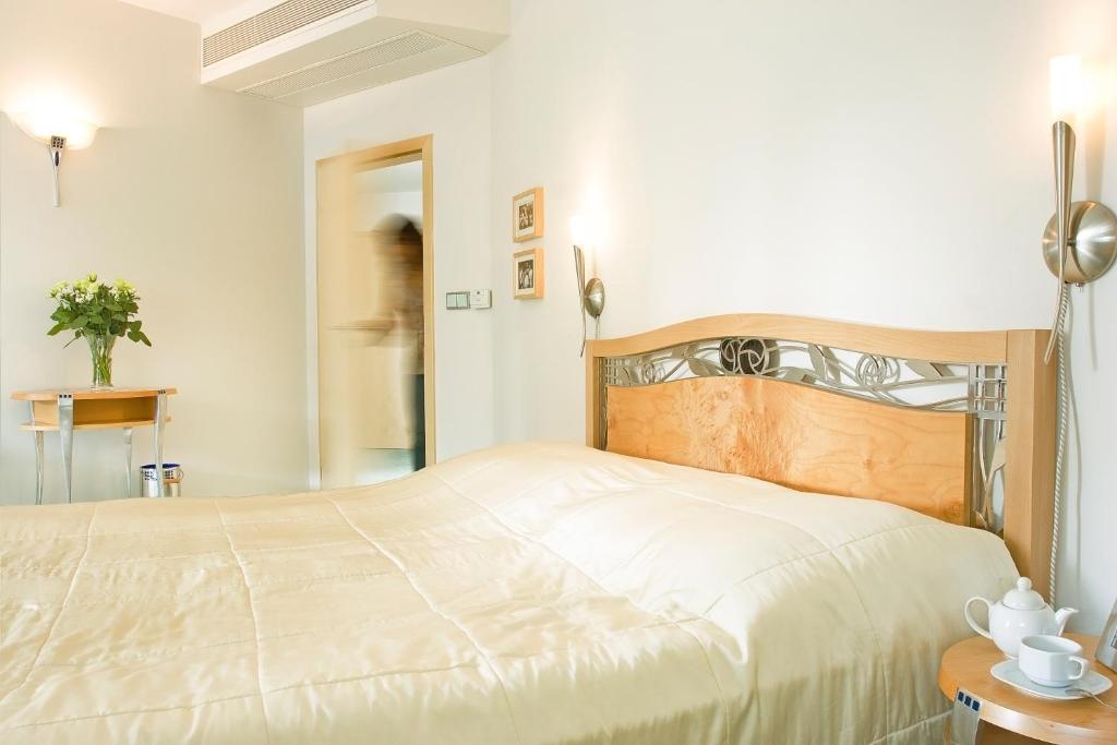 ブラチスラヴァにあるホテル セットのベッドルーム(白いシーツを使用した大型ベッド1台付)