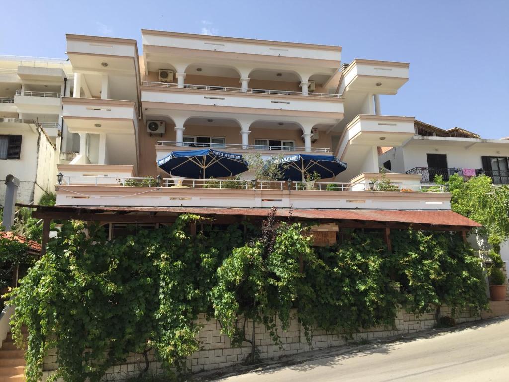 a building with umbrellas on the side of it at Firenze Apartments in Ulcinj