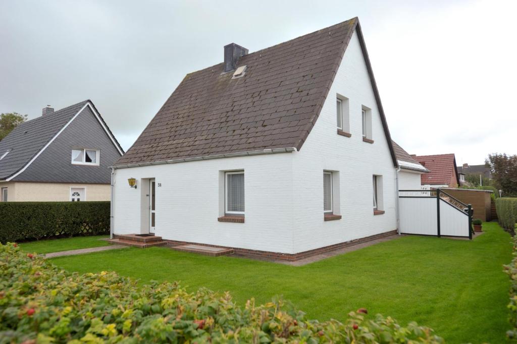 ein weißes Haus mit schwarzem Dach in der Unterkunft Wohnung Sylthome in Westerland