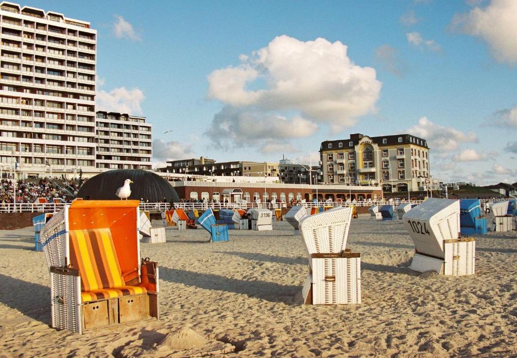 韋斯特蘭的住宿－Appartement-Makrele，海滩上设有沙滩椅,建筑背景