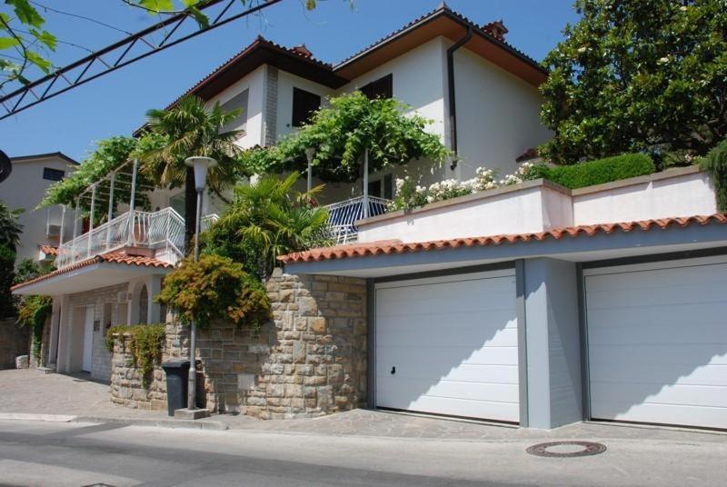 una casa con dos puertas de garaje delante de ella en Villa Lili, en Portorož