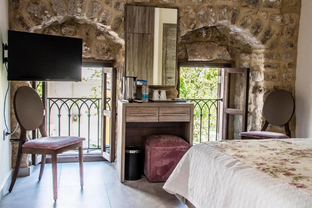 a bedroom with a bed and a fireplace and a tv at Asamina Boutique Hotel in Soûr