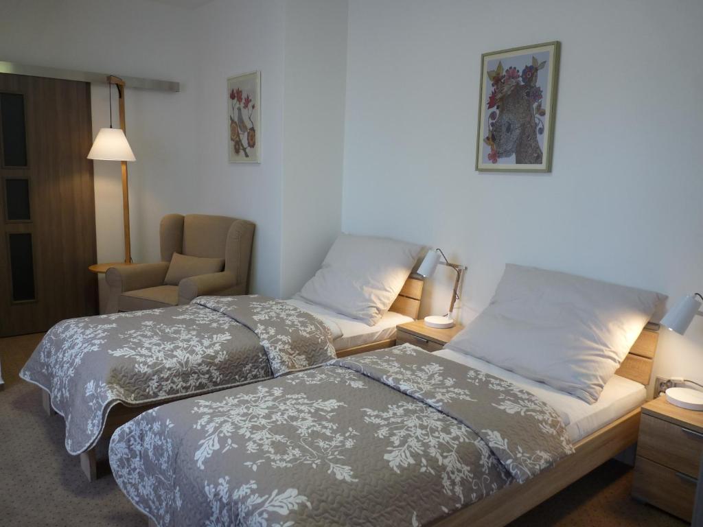 um quarto de hotel com duas camas e uma cadeira em Farma Loreta em Vlasim