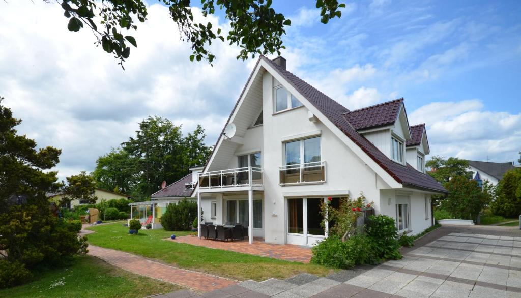 uma casa branca com um telhado de gambrel em Landhaus Dreesen em Timmendorfer Strand