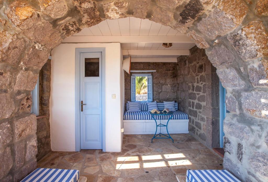 a room with blue and white pillows and a window at Theologos Houses in Grikos
