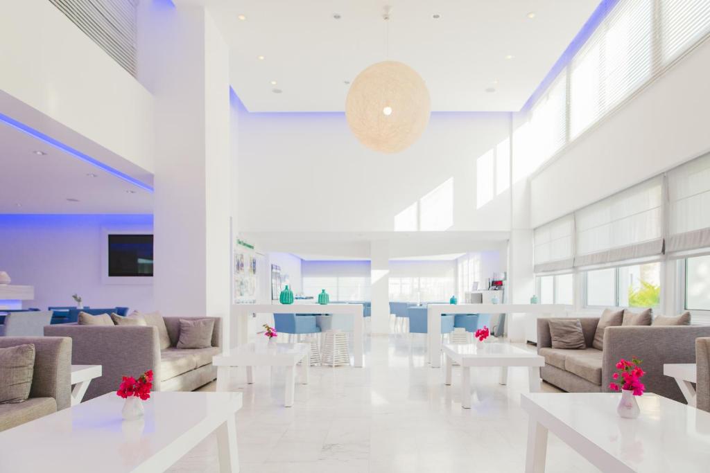 a lobby with couches and tables in a building at Nissi Park Hotel in Ayia Napa
