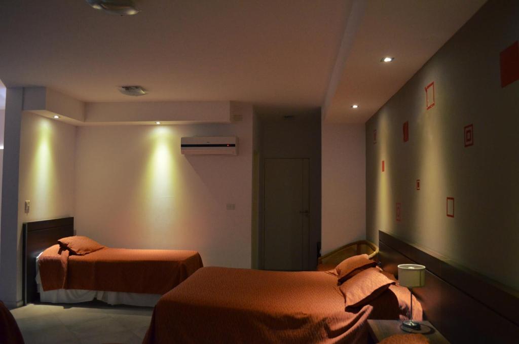 ein Hotelzimmer mit 2 Betten in einem Zimmer in der Unterkunft Hotel La Posada del Viajero in Río Cuarto