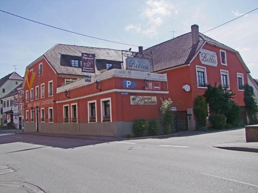 a red building on the corner of a street at Hotel Beller in Kenzingen