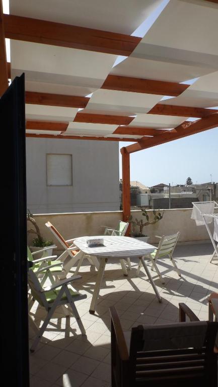 プンタ・セッカにあるCasa Vacanze Kamarinaのパティオ(屋上に白いテーブルと椅子付)