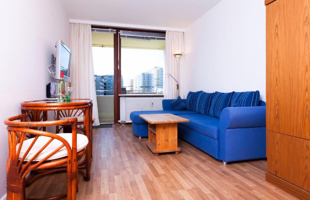 ヴェスターラントにあるSylter-Seestern-Appartement-14のリビングルーム(青いソファ、テーブル付)