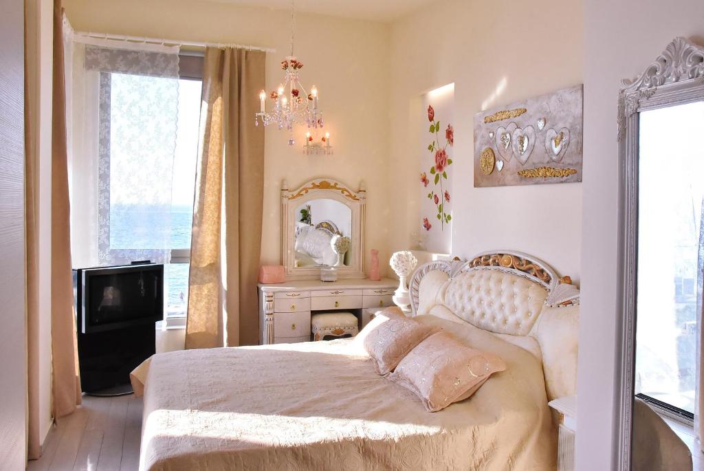 sypialnia z łóżkiem, komodą i lustrem w obiekcie Sea View Beachfront Villa Maria w mieście Guwes