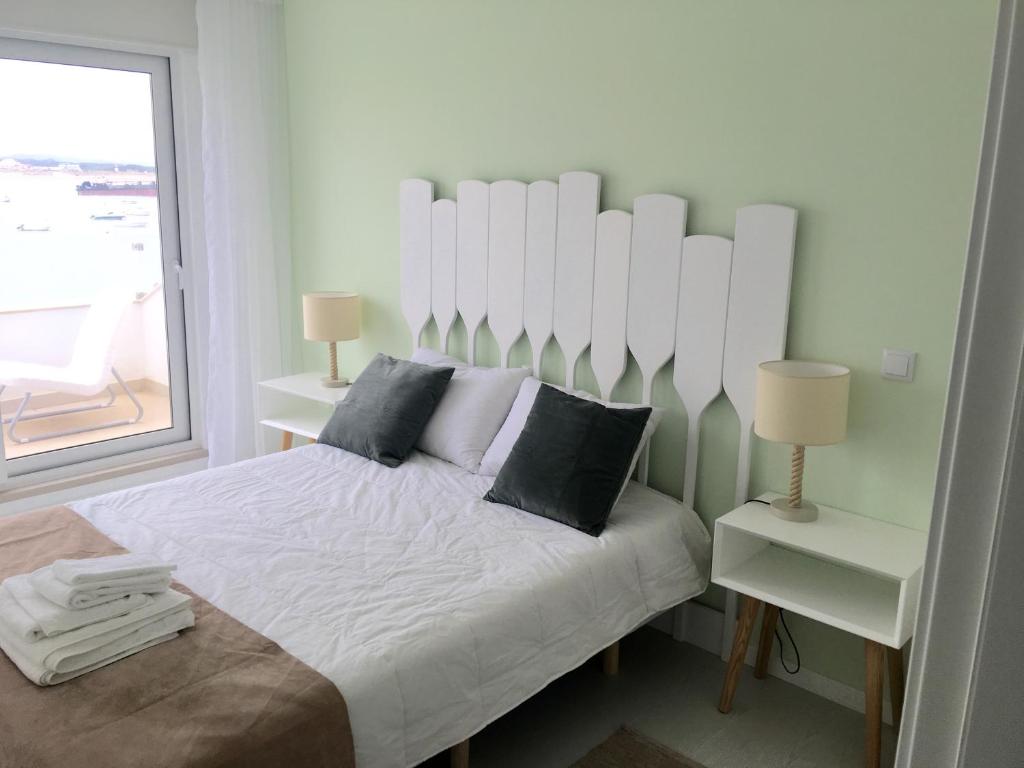 サン・マルティーニョ・ド・ポルトにあるSerene Waterfront Apartmentの白いベッドルーム(枕付きの大きな白いベッド付)