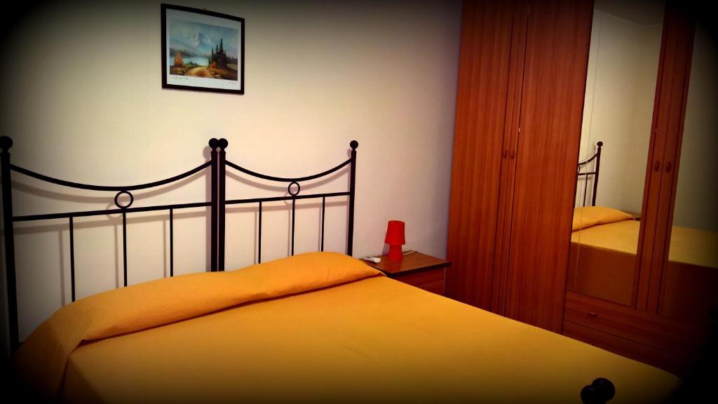 a bedroom with a bed with an orange blanket at Casa Vacanza Apollo in Siracusa