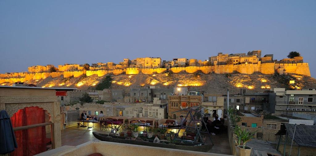 Shahi Palace Hotel Jaisalmer في جيلسامر: اطلالة على مدينة يوجد مباني على تلة