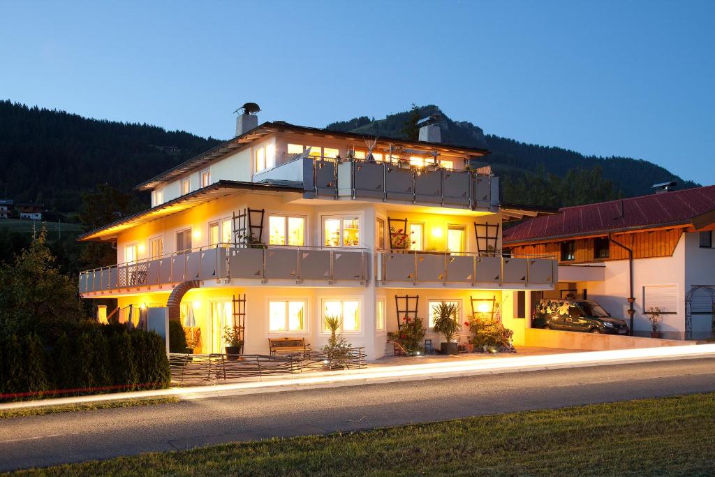 a large white building with lights on it at night at Appartementhaus Charisma in Fieberbrunn