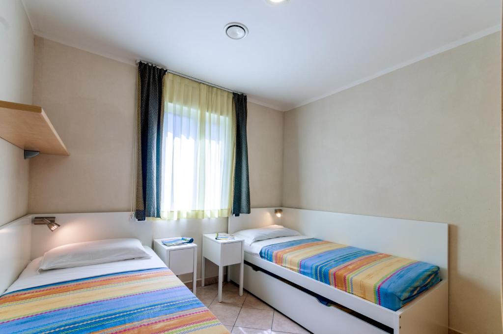 Postel nebo postele na pokoji v ubytování Camping Village Du Parc