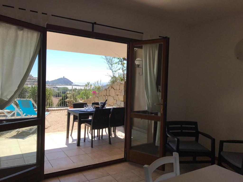 a room with a glass door leading to a table and chairs at Sa Tirìa in Chia