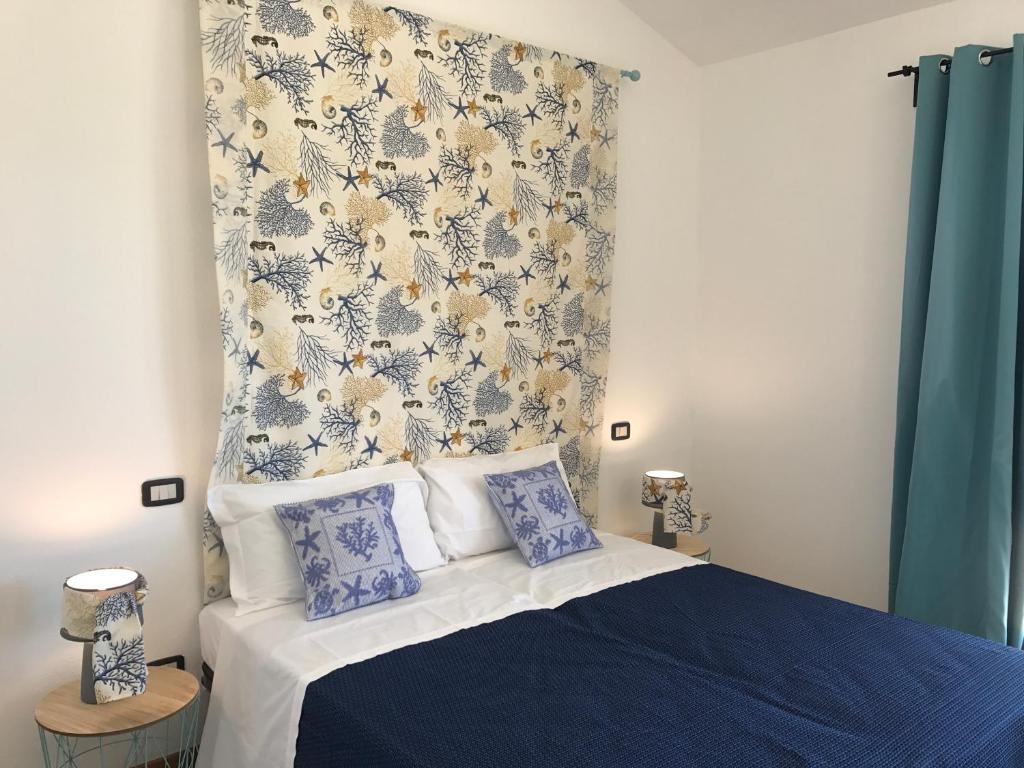 a bedroom with a bed with blue and white pillows at Sa Tirìa in Chia