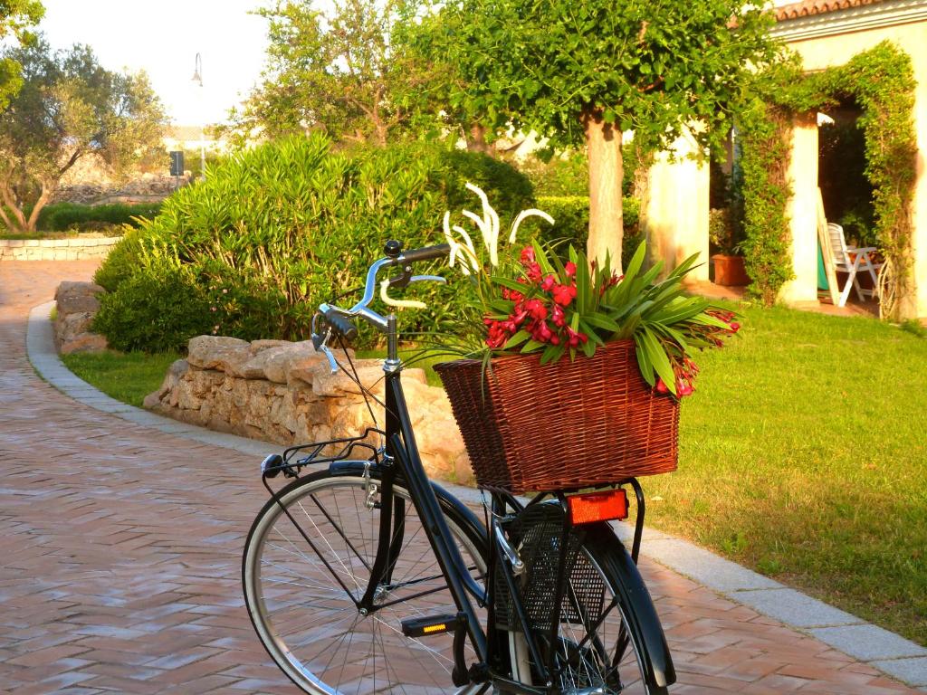 una bicicletta con un cesto di fiori di Il Borgo Appartamenti by KasaVacanze a Porto San Paolo