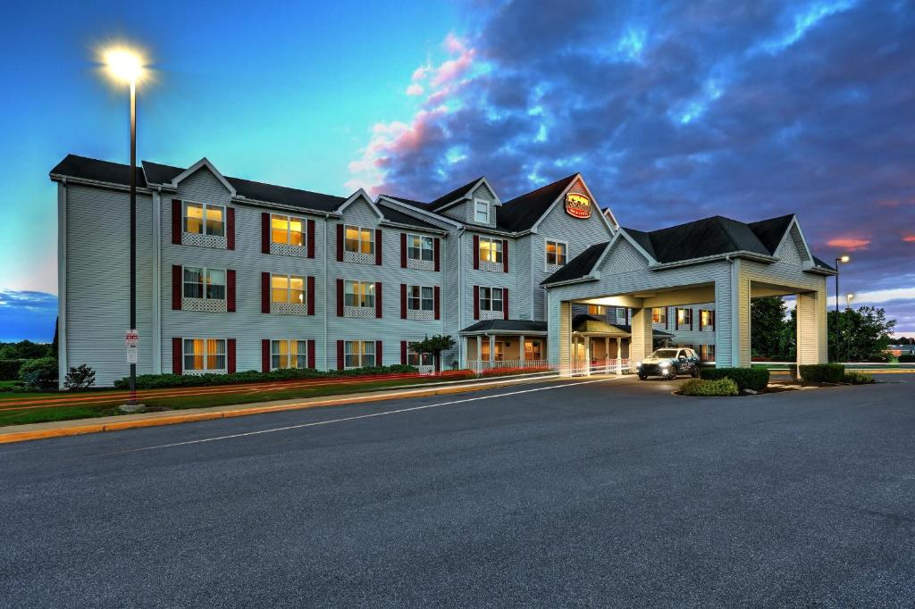 um grande edifício branco no lado de uma rua em Lancaster Inn & Suites em Manheim