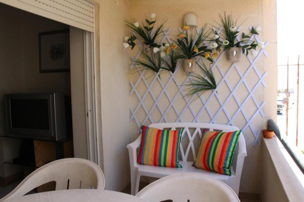 コスタ・ダ・カパリカにあるCaparica Costa Azulの白い椅子(壁にカラフルな枕付)
