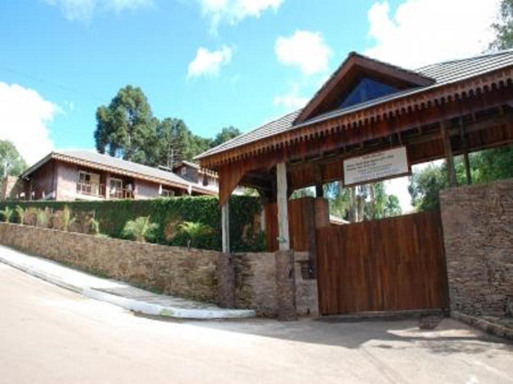 a house with a wooden gate and a building at Hotel Pousada Mata Nativa in Passo Fundo