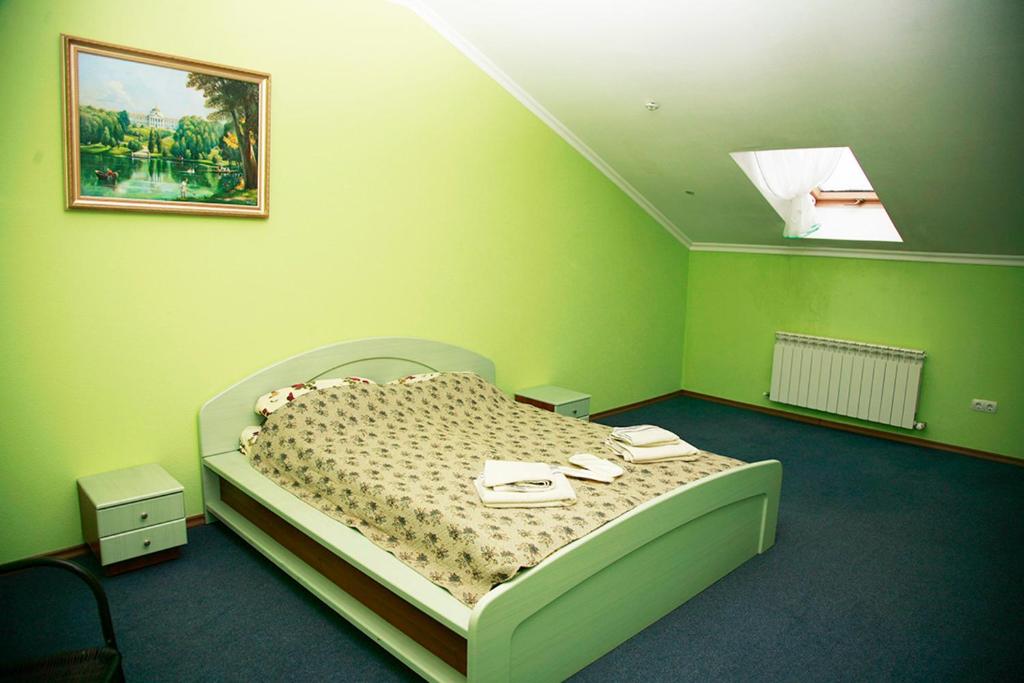 a green bedroom with a bed with shoes on it at Sava Dream in Zhytomyr