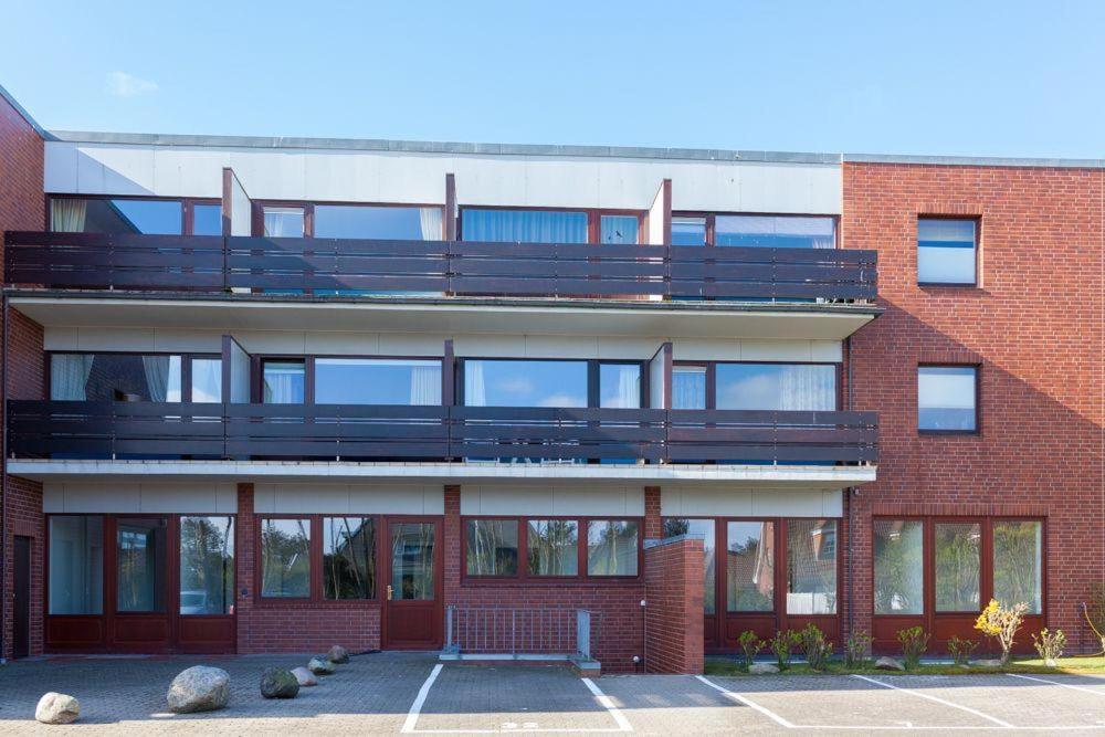 a red brick building with a balcony on it at Appartment-19-Sylter-Robbe in Wenningstedt