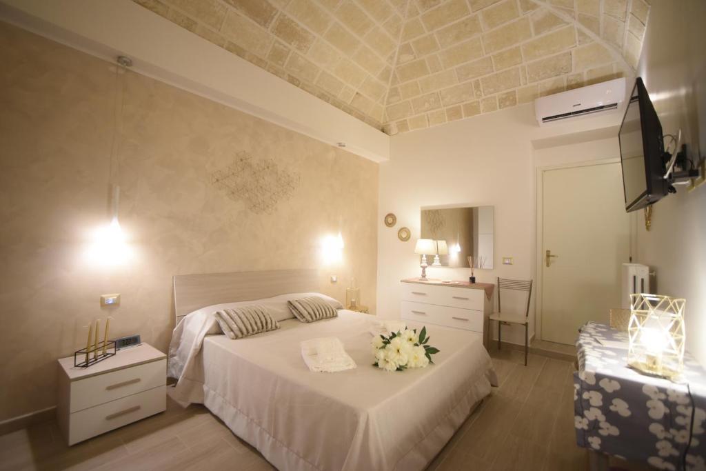 una camera da letto con un letto bianco e fiori di CASA FELICE Maison de Charme a Taranto