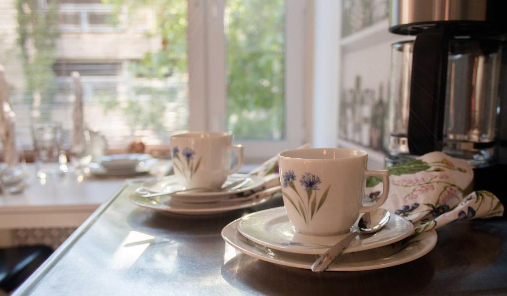 two cups and saucers sitting on a counter top at Lahti Alex House in Lahti