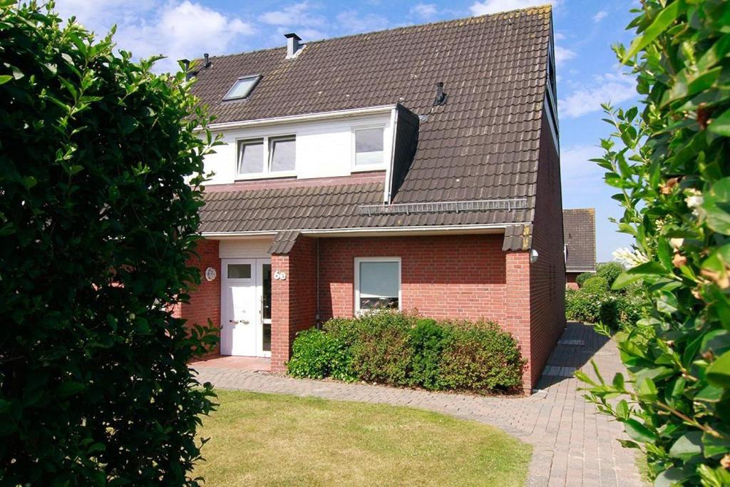 a red brick house with a gambrel roof at Wohnung-re-Sylter-Boje in Wenningstedt