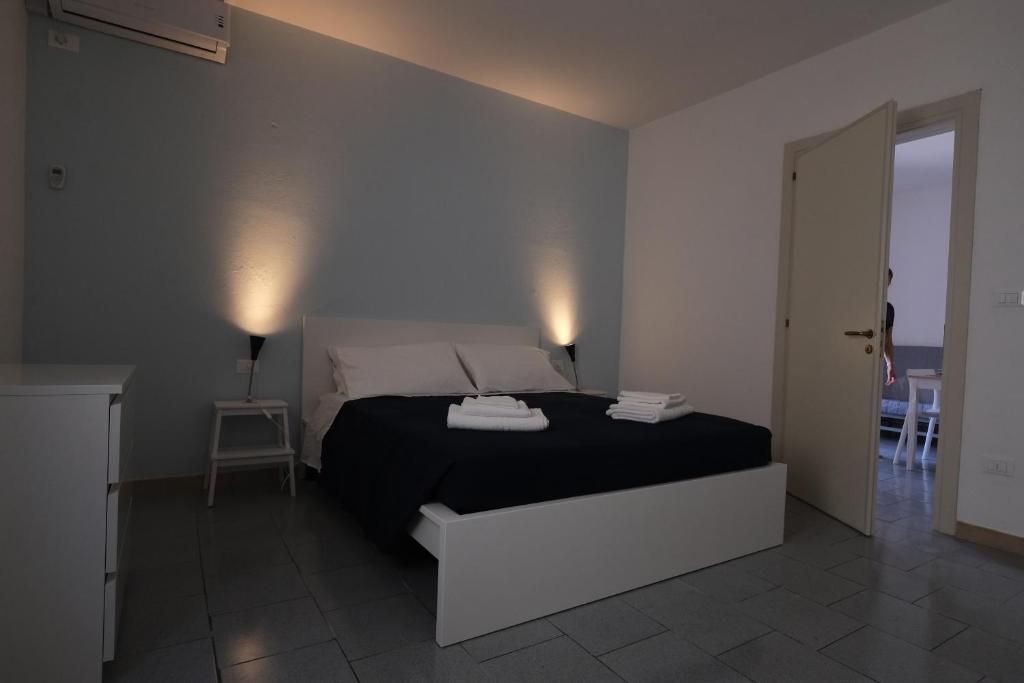 um quarto com uma cama preta e branca num quarto em Case al mare in Salento em Leuca