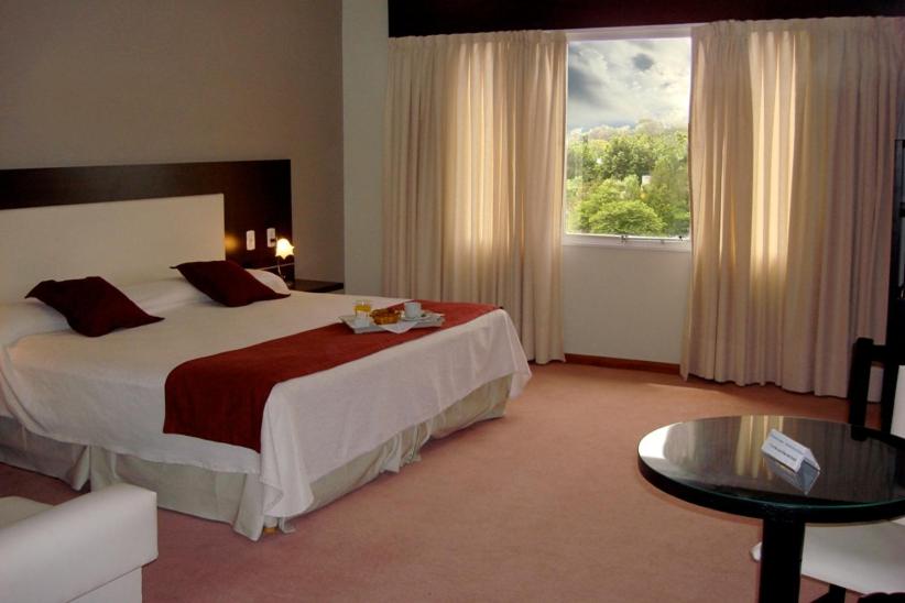 a hotel room with a large bed and a window at Hotel Cuatro Plazas in Casilda