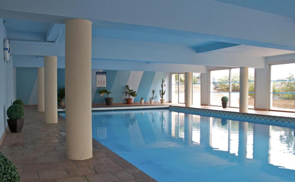 a swimming pool with a large pool table and chairs at Hotel Europa in Quiberon