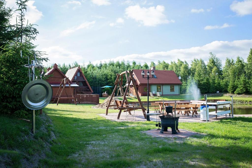 un parc avec une aire de jeux avec un toboggan et une balançoire dans l'établissement Lodges Zacisze I, à Giżycko