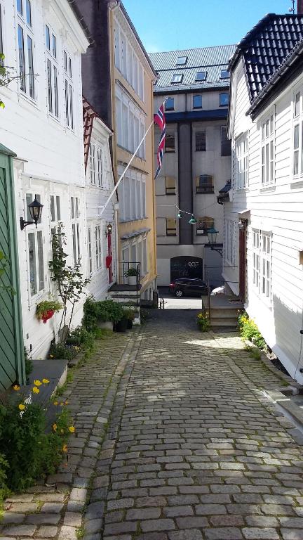 a cobblestone street in a town with white buildings at The White House in Bergen