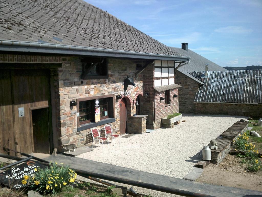 un edificio de ladrillo con un patio delante de él en B&B Chambre d'hôtes de la Vecquée, en Stoumont