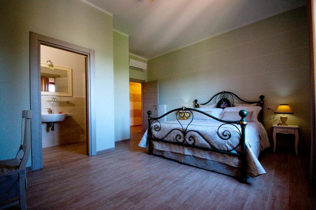 a bedroom with a bed and a bathroom with a sink at B&B La Madonnina in Montefalco