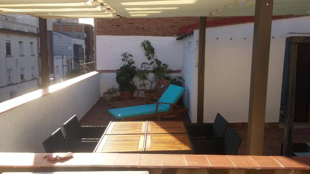 Un balcón con una silla azul y una mesa en LG Big Flat Barcelona en Badalona