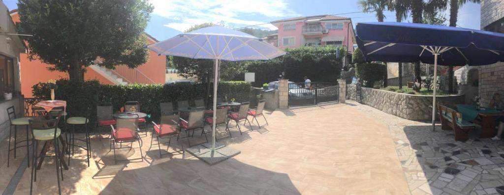 a patio with chairs and tables and umbrellas at Guesthouse Villa Manda in Lovran
