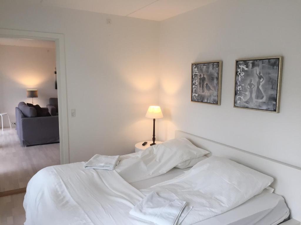a white bed in a white bedroom with a lamp at CITY, LUX APARTM - 2 FULL BATHROOMs, 1v in Copenhagen
