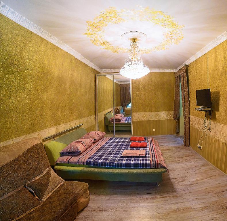 una camera con letto, divano e lampadario a braccio di One bedroom Apartment on Svobody Square a Cherson
