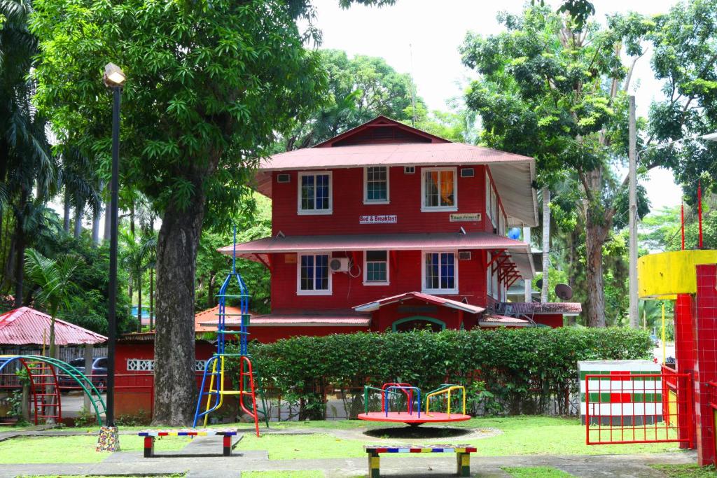 una casa roja con un parque infantil delante de ella en Hostal Amador Familiar, en Panamá