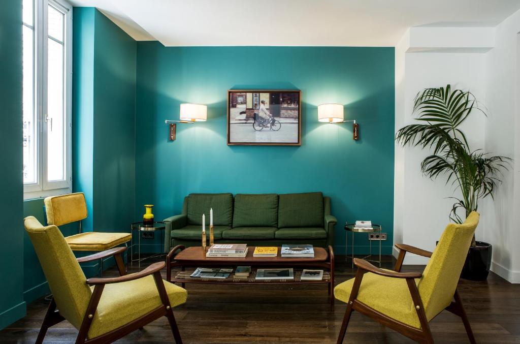 パリにあるHôtel Beaurepaireのリビングルーム(緑のソファ、椅子付)
