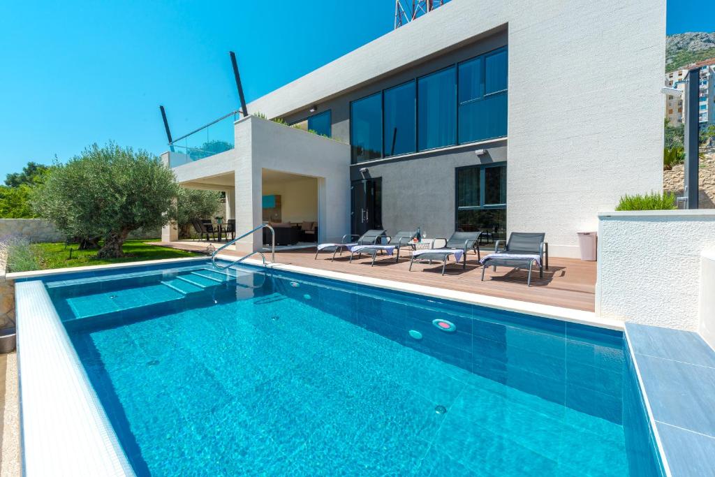 - une piscine en face d'une maison dans l'établissement Villa Lu sea view-gym-sauna-hot tub,pool, à Mokošica