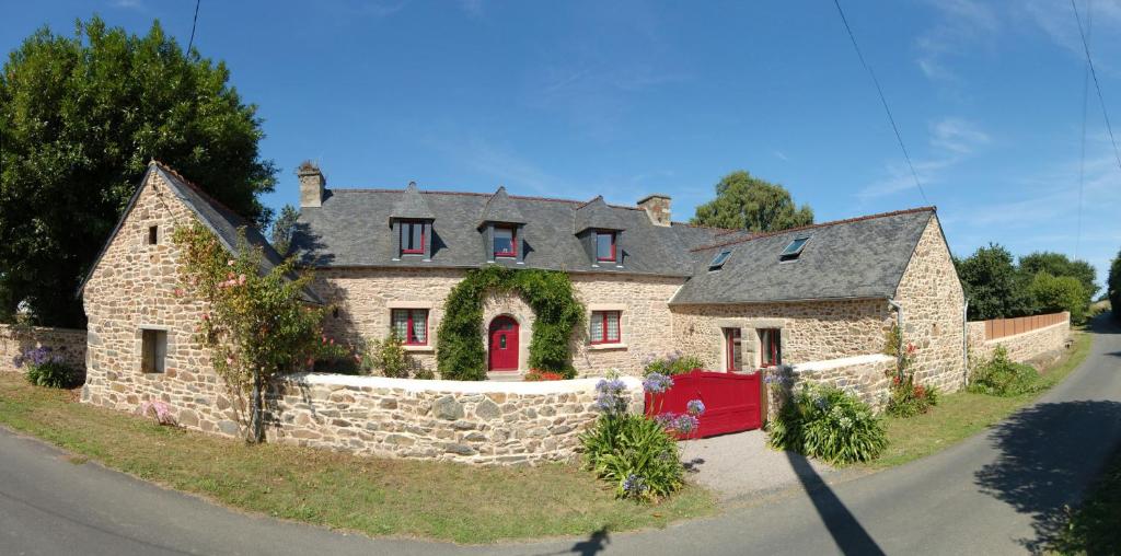 una gran casa de piedra con una pared de piedra en Les longères du Trieux, en Lézardrieux