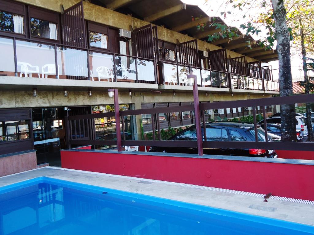 a swimming pool in front of a building at Mira Maré Praia Hotel in Guarujá